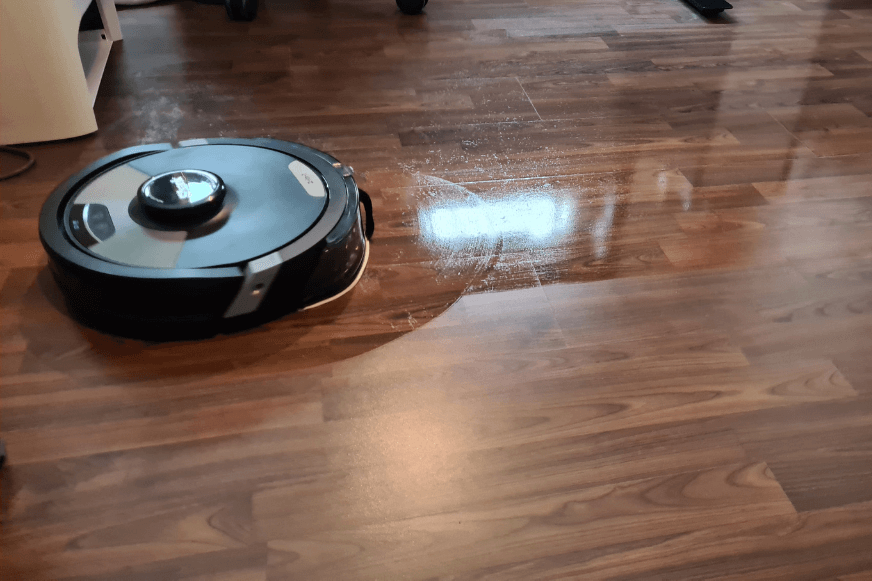 Die Schrubbbewegungen eines Shark Saugroboters mit Wischfunktion sind auf dem Boden zu sehen. 